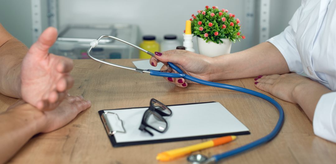 Doctor and patient sitting at a desk with stethoscope