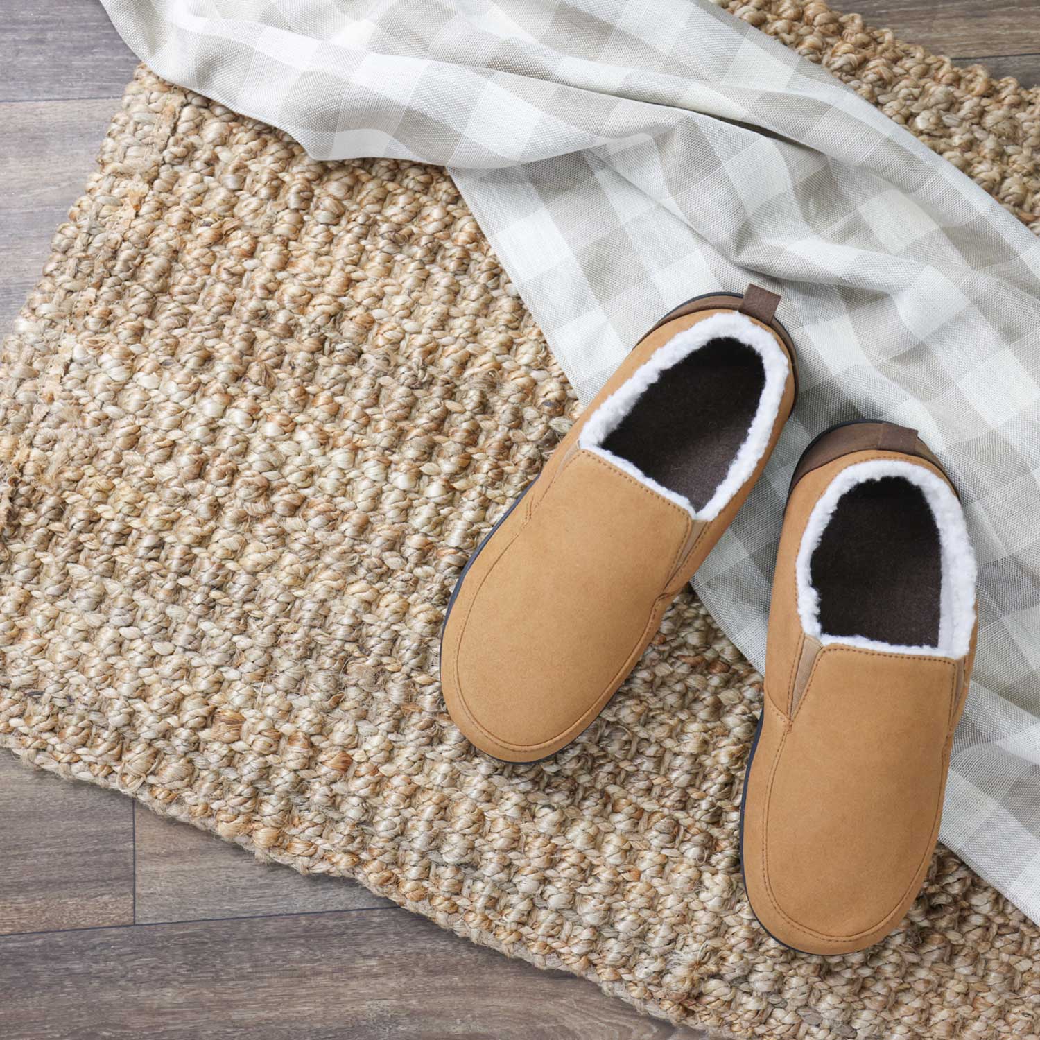 Pair of tan slippers with white fur lining on a textured mat.