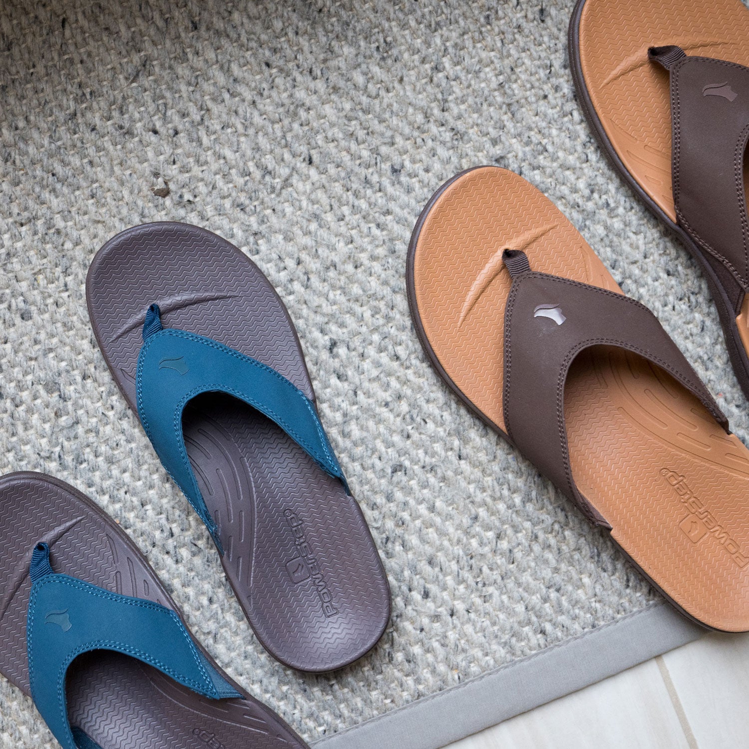 Brown and dark teal women's orthotic sandals next to brown and light brown men's orthotic sandals