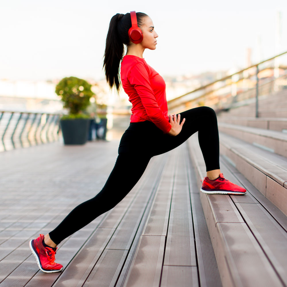 Woman outside stretching legs on stairs