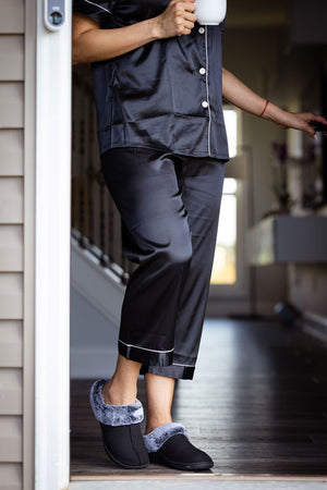 Woman opening front door while wearing PowerStep Orthotic Slippers.