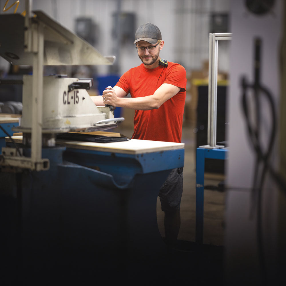 Man working on machine at work while wearing PowerStep Pinnacle Work insoles for standing all day